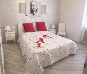 ガルドーネ・リヴィエラにあるLa Rosa Del Garda Apartmentの白いベッド(赤い枕、タオル付)