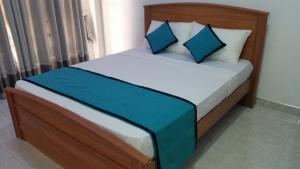 un letto con cuscini blu in una stanza di Sunhill Lake Tourist Rest a Anuradhapura