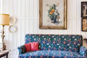 a living room with a blue couch with a vase of flowers at Residenza d'Epoca Albergo Quattro Fontane in Venice-Lido
