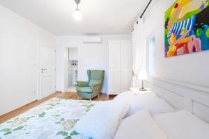 een witte kamer met een bank en een stoel bij Apartments Rialto Gallery in Šibenik