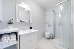 La salle de bains blanche est pourvue d'un lavabo et d'une douche. dans l'établissement Apartments Rialto Gallery, à Šibenik