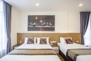a hotel room with two beds and a picture on the wall at Natura Hotel in Nusajaya