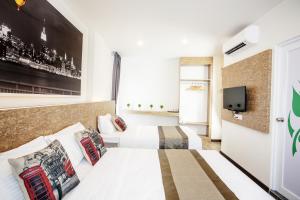 ein Hotelzimmer mit 2 Betten und einem TV in der Unterkunft Natura Hotel in Nusajaya