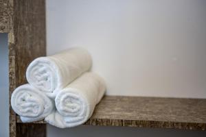 a stack of towels sitting on a wooden shelf at Natura Hotel in Nusajaya