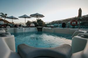 Servatur Casablanca Suites & Spa - Adults Only في بورتو ريكو: مسبح مع كراسي ومظلات