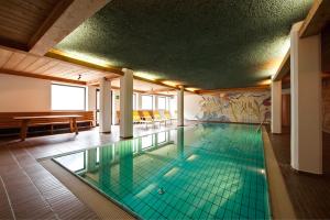 een groot zwembad in een grote kamer met bij Residence Am Wegkreuz in Senales