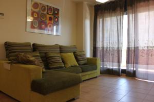 a living room with a couch and a window at Apartamento con piscina a 300m playa Fenals-Lloret in Lloret de Mar