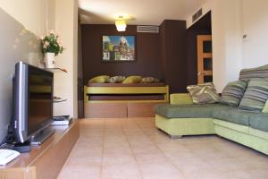 sala de estar con sofá y TV en Apartamento con piscina a 300m playa Fenals-Lloret, en Lloret de Mar
