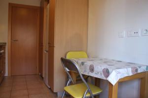Habitación pequeña con mesa y 2 sillas en Apartamento con piscina a 300m playa Fenals-Lloret, en Lloret de Mar