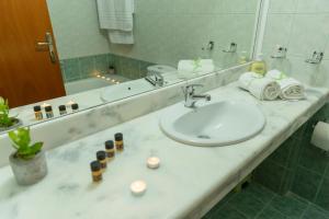 a bathroom counter with a sink and a mirror at Stegna Bay Apartment in Archangelos +18 photos