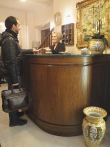 a man and woman standing behind a counter at a bar at Hotel Santa Croce in Florence
