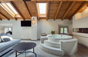 a living room with a tub and a couch at Relais Ginevra in Zocca