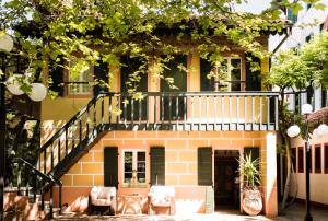 a house with a balcony and chairs in front of it at Residenza d'Epoca Albergo Quattro Fontane in Venice-Lido