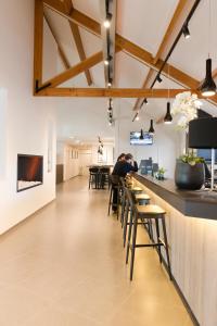 a person sitting at a bar in a restaurant at Best Western Hotel Wavre in Wavre