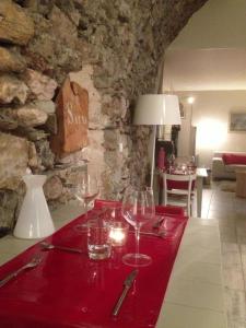 a table with wine glasses and a stone wall at Chambre d'hôtes La Font in Eygliers