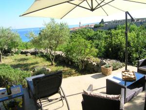 a patio with a table and chairs and an umbrella at Apartments Dagmar in Krk