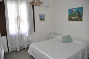 サン・ヴィート・ロ・カーポにあるAzzurromareの白いベッドルーム(ベッド1台、窓付)
