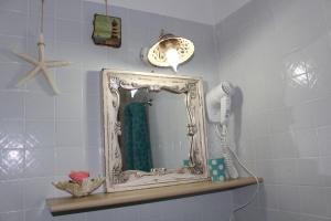 uno specchio su una mensola in bagno di Azzurromare a San Vito lo Capo