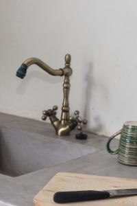 a kitchen sink with a knife and a faucet at Kafka Stone House in Emporeiós