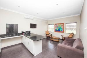 a kitchen and living room with a couch and a table at Vetho 2 Apartments OR Tambo Airport in Kempton Park