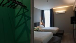 Cette chambre comprend 2 lits et un mur vert. dans l'établissement G Hotel Pescara, à Pescara 37 autres photos