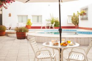 una mesa con comida junto a una piscina en Hotel Carollo en Mendoza