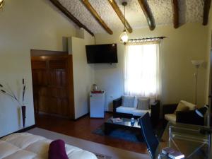 a living room with a bed and a tv and a couch at Casa de Campo Santa Rosa in Cajamarca