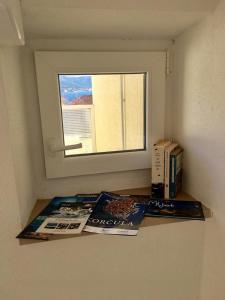 dos revistas sentadas en un estante junto a una ventana en Linda Apartment, en Korčula