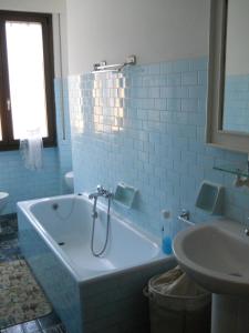a blue bathroom with a tub and a sink at Appartamento Bordighera in Bordighera