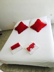 Una cama blanca con 4 almohadas rojas. en Linda Apartment, en Korčula