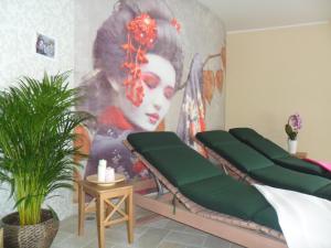 um quarto com quatro bancos verdes em frente a um mural em Hotel da Giacomino em SantʼAndrea