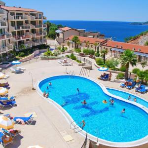 a swimming pool at a resort with people in it at Montetrest Apartments in Sveti Stefan