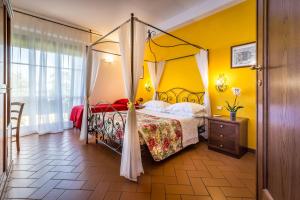um quarto com uma cama de dossel e paredes amarelas em B&B Antiche Armonie em Florença