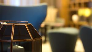 a close up of a lamp with a blue chair at G Hotel Pescara in Pescara