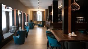 a restaurant with blue chairs and a table and a dining room at G Hotel Pescara in Pescara
