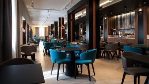 un restaurant avec des tables et des chaises bleues dans l'établissement G Hotel Pescara, à Pescara