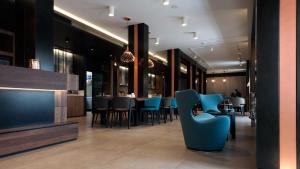 a dining room with blue chairs and a bar at G Hotel Pescara in Pescara