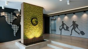 a lobby with a wall with a sign on it at G Hotel Pescara in Pescara