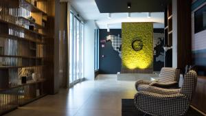 a lobby with two chairs and a green wall at G Hotel Pescara in Pescara