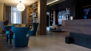 un hall avec des chaises bleues et un lustre dans l'établissement G Hotel Pescara, à Pescara