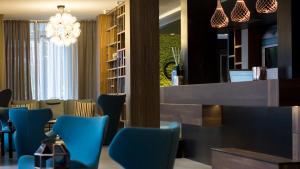 a dining room with blue chairs and a bar at G Hotel Pescara in Pescara