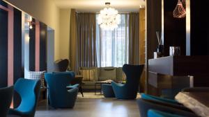 a living room with blue chairs and a chandelier at G Hotel Pescara in Pescara