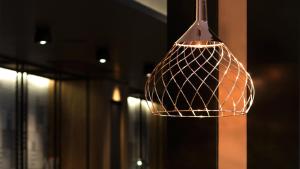 a copper pendant light hanging from a wall at G Hotel Pescara in Pescara