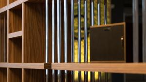 a wooden book shelf with a parrot in a cage at G Hotel Pescara in Pescara