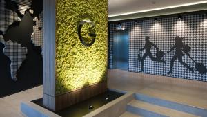 a lobby with a sign on the wall and stairs at G Hotel Pescara in Pescara