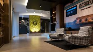 a lobby with chairs and a clock on the wall at G Hotel Pescara in Pescara