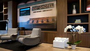 a lobby with two chairs and a large screen at G Hotel Pescara in Pescara