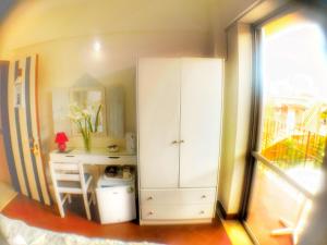 a bedroom with a white cabinet and a desk at Avra Boutique in Benitses