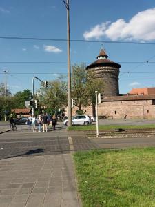 a group of people walking on a street with a tower at Ferienwohnung "Elsnerstrasse" in Nuremberg