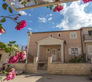 una casa con fiori rosa di fronte di Apartments Gabelic a Hvar